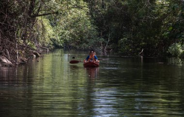 Nakhon Ratchasima, Tayland. Mar - 20, 2022: İki maceraperest kadın ormanda kırmızı kayak yaparken birlikte eğleniyorlar. Boş zamanlarımızda, doğa ve turistik aktivitelerde eğleniyoruz. Tam olarak odaklanamıyorum..