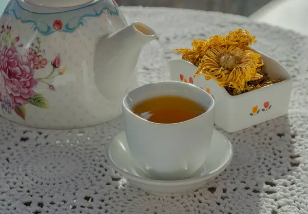 Chinese chrysanthemum flower tea and Dried chrysanthemum flower on crochet cotton Lace table placemat. Healthy beverage for drink. Herbs and medical concept. Space for text, Selective focus.