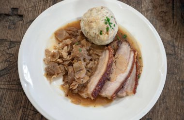 Staw Domuzu 'ndan Bierbratl. Ev yapımı koyu bira soslu domuz eti. Bavyera lahanası ve seramik tabakta ekmek köftesi ile servis ediliyor. Üst görünüm, metin için boşluk, Seçici odak.