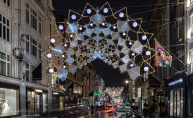 Londra, İngiltere - 25 Aralık 2023 - Noel Taç Dekorasyonları ışık gösterimine yol açtı. Alacakaranlıkta Bond caddesinde asılı geleneksel Noel dekorasyon ışıklarının dramatik manzarası, Noel Ruhu, Londra 'da Işık Festivali, Kopyalama alanı, Seçici odak
