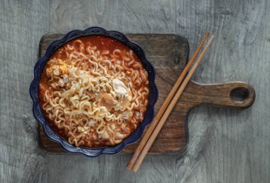 Yumurta ve seramik kasede arpacık soğanı ve tahta kesme tahtasının üzerinde baharatlı Tom yum eriştesi. Kolay şehriye yemeği, Top view, metin için alan, seçici odaklanma.