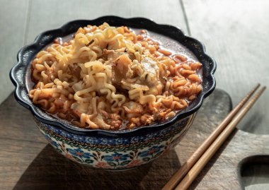 Yumurta ve seramik kasede arpacık soğanı ve tahta kesme tahtasının üzerinde baharatlı Tom yum eriştesi. Kolay şehriye yemeği, üstten bulanık görünüm, metin için boşluk, seçici odak.