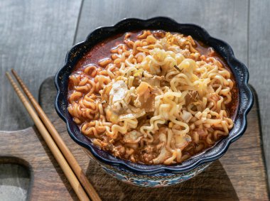 Yumurta ve seramik kasede arpacık soğanı ve tahta kesme tahtasının üzerinde baharatlı Tom yum eriştesi. Kolay erişte yiyecekler, üstten gizli görüş, boşluğu kopyalamak, seçici odaklanma..