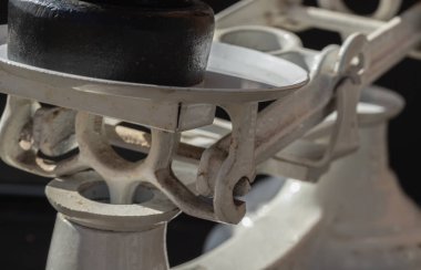 Koyu arkaplanda izole edilmiş klasik ağırlık ölçeği. Eski el kitabının ayrıntıları dökme demir ağırlıklarla tartılıyor. Antika dengesi, kopyalama alanı, Seçici Odaklanma.