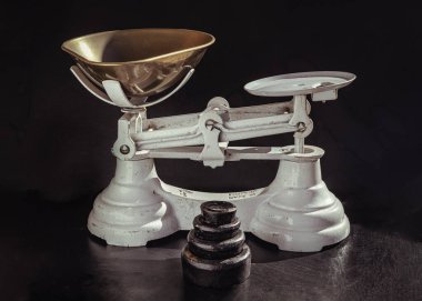 Eski el işi teraziler ve dökme demir ağırlıklar setiyle Demir Pirinç Tepsi. Koyu arkaplanda izole edilmiş klasik ağırlık ölçeği, antika denge ölçeği, metin için alan, Seçici Odaklanma.