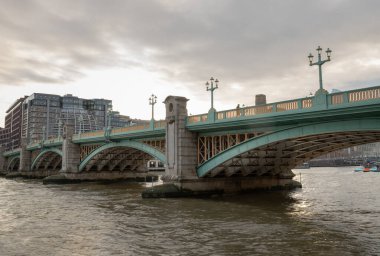 Londra, İngiltere - 27 Şubat 2024 - Londra 'daki Thames Nehri' ni geçen Southwark Köprüsü manzarası. Bir turkuaz döküm demir köprü, eğri çelik köprü, metin için boşluk, seçici odak.
