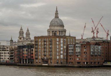Londra, İngiltere - 27 Şubat 2024 - Londra 'daki Thames Nehri boyunca uzanan diğer inşaat ve binalarla çevrili St. Pauls Katedrali' nin Meşhur Kubbesi 'ne doğru bakın. Metin için boşluk, Seçici odak.