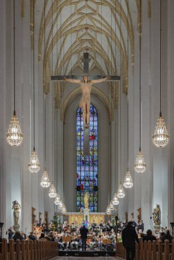 Münih, Almanya - 21 Aralık 2023 - Frauenkirche 'deki Senfoni Orkestrası konseri. Meryem Ana 'nın Katedrali' nin iç tarafında çarmıhta asılı duran İsa 'nın mimarisi Münih' in en simgesidir. Metin için boşluk, Seçici odak.