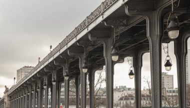 Fransa, Paris - Ocak 04, 2024 - Paris 'teki Pont de Bir Hakeim köprüsünün güzel manzarası. Passy Viyadük 'teki metronun Metal sütunları ve Art Deco sokak lambalarının perspektif görüntüsü, metin için alan, seçici odak.