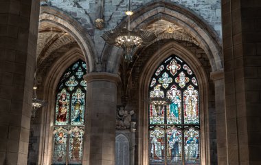 Edinburgh, İskoçya - 18 Ocak 2024 - St Giles Katedrali 'ndeki ya da High Kirk' teki devedikeni şapelinin içindeki Güzel Avize ve Cam boyalı pencere. Edinburgh 'daki en önemli ibadet yeri, metin için alan, seçici odak.