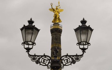 Berlin, Almanya - 20 Aralık 2023 - Arka planda zafer sütunu olan sokak lambası direği. Prusya 'nın Tiergarten' deki Fransız-Alman savaşındaki zaferini kutlamak için Tanrıça Victoria ile birlikte Zafer sütununun üst kısmında. Metin için boşluk, Seçici fo