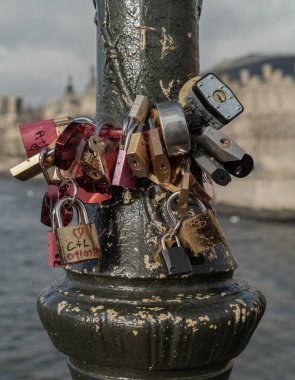 Fransa, Paris - Ocak 03, 2024 - Birçok asma kilit köprüdeki siyah çelik sütuna kilitlendi. Aşk dilekleri için birbirine bağlı aşk kilitleri, ilişkinin dayanıklılığının sembolü, Kalabalık Aşk Asma Kilitleri, metin için boşluk, Seçici odak.