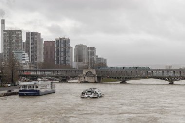 Fransa, Paris - Ocak 04, 2024 - Seine nehri üzerindeki Pont de Bir Hakeim köprüsü boyunca yelken açmak. Paris 'teki Pont de Bir Hakeim Köprüsü ve Yüksek İş Binaları' ndan geçen bir metro görüntüsü, Avrupa 'daki Destinasyonlar, metin için yer, seçici odaklanma.