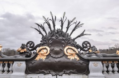 France, Paris - Jan 04, 2024 - Backside of Nymphes de la Seine sculpture of the downstream parapet of the Alexander III Bridge (Pont Alexandre III) with sky background in Paris. Space for text, Selective focus. clipart