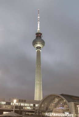 Berlin, Germany - Dec 18, 2023 - Night view of Alexanderplatz neon sign with Berlin Television Tower (Fernsehturm) and Train station in Mitte Berlin, A Tourist attraction and Meeting place, Space for text, Selective focus. clipart