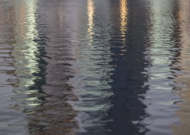 Işık yansımalı bir gölün suyunda dalgalanmalar. Su yüzeyindeki soyut fotoğraf sanatı yansıması, su dalgası arkaplanı, metin için alan, seçici odak.