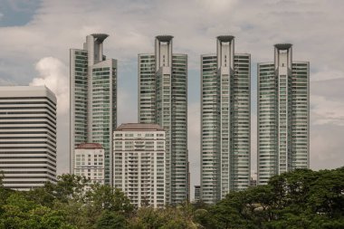 Bangkok, Tayland - 22 Haziran 2024 - Milenyum Konut binaları ve genel binaların mimarisi. Gökyüzü arka planı ve yeşil alanlar üzerine modern yüksek binalar, metin için alan, seçici odak.