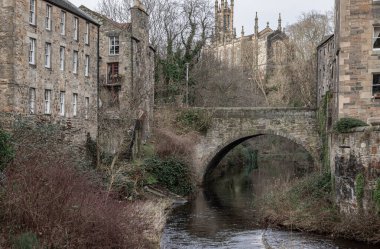Edinburgh, İskoçya - 16 Ocak 2024 - Dean Village 'dan Kutsal Üçleme Kilisesi' ne, şimdi Dean Bridge ile Rhema Hristiyan Merkezi Kilisesi 'ne ve Dean Village' dan akan Leith Suyu 'na bakış. Boşluğu kopyala, Seçici odak.