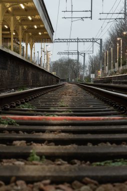 Londra, İngiltere - 25 Aralık 2023 - Düşük perspektiften demiryolu rayları. Odak derinliği sınırlı demiryolu rayları, Demiryolu platformunun metal çerçeveli demiryolu sistemi, raylar, tren rayları, tren istasyonu, mesaj için yer, Selecti