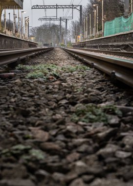 Londra, İngiltere - 25 Aralık 2023 - Düşük perspektiften demiryolu rayları. Odak derinliği sınırlı demiryolu rayları, Demiryolu platformunun metal çerçeveli demiryolu sistemi, raylar, tren rayları, tren istasyonu, mesaj için yer, Selecti