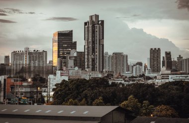 Bangkok, Tayland - 14 Ağustos 2024 - Bangkok şehrindeki Dramatik gökyüzünün modern yüksek binalarının mimarisi. Gün batımından önce gökdelenlerin resimli görünümü, metin için boşluk, Seçici odak.