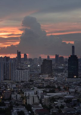 Bangkok, Tayland - 23 Ağustos 2024 - Gökyüzündeki Güzel Bulutların Büyük Metropolitan Şehri üzerindeki görüntüsü. Gün batımından sonra Bangkok gökdelenleri Sunset öncesi dramatik arkaplan, metin için alan, seçici odak.