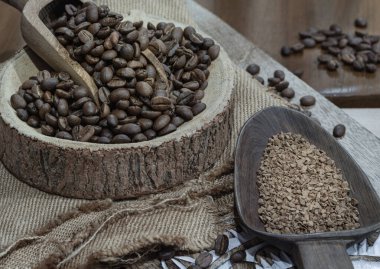 Tahta kâse üzerinde ahşap kepçe içinde kahve çekirdekleri çuval bezi ve tahta kesme tahtasının üzerinde tahta kaşıkta kahve. Yaşam konsepti için alternatif kahve, metin için alan, seçici odak.