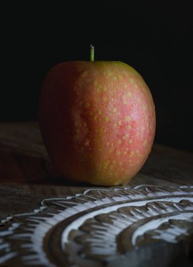 Taze bir öpücük elma meyvesi. Ahşap kesme tahtasının üzerinde minimalist tarzda eşsiz bir lezzet tadı olan doğal pembe et. Işık ve Gölge, Boşluğu Kopyala, Seçici Odak.