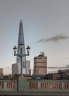 Londra, İngiltere - 15 Şubat 2024 - Köprü önünde sokak lambaları olan Çömlek Gökdeleni manzarası. Boşluğu kopyala, Seçici Odaklanma.