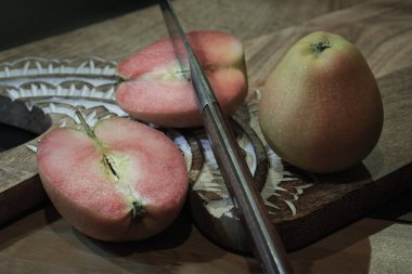 Fresh kissabel apple fruit and Cut the apple in each half with knife on wooden cutting board. Naturally pink flesh kissabel apple with a unique zesty taste, Copy space, Selective Focus. clipart