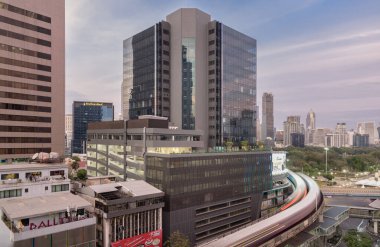 Bangkok, Tayland - 31 Aralık 2022 - BTS Sky tren yolu ve kavşak köprüsü şehir merkezinden geçerken, merkez iş bölgesinde gündüz vakti trafik vardı ve arka planda Bangkok 'un skycraper binası vardı. Ulaşım 