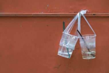 Plastik bardakta kalan su veya pipetli plastik bardak, festivalde içildikten sonra turuncu çelik duvara asılıyor. Çöpü herhangi bir yere dikkatsizce atan insanlar çöp tenekesi değil, çevre dikkatsizce konsepti. Metin için boşluk, Seçici 