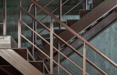 Duvara dayanan tırabzanları olan eski metal merdivenlerin yan görüntüsü. Çelik merdiven dikey görünümü, metin için boşluk, Seçici Odaklanma.