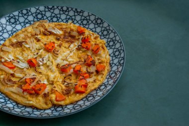 Kahvaltıda. Güzel bir tabakta soğan, havuç ve lahana ile nefis ev yapımı yumurta omleti. Üstten kopyalama alanı ile mat görünüm.