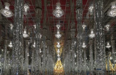 Uthai Thani, Tayland - 06 Aralık 2024 - Kristal tapınağın içindeki, Wat Chantaram veya Tha sung kristal tapınağındaki parlak, aynalı döşeme ve sütunlarla süslenmiş Shinaratr Buda Heykeli (Wat Tha Sung). Bunu kullan.