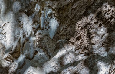 Güneş ışığı kireçtaşı duvarlarından aşağıya, mağara duvarlarına kadar parlıyor. Karmaşık doğal ışığın zerafeti ve taş duvarın yüzeyindeki gölge, doğal olarak aşınan dağlardaki granit deseni, bunu duvar kâğıdı, poster olarak kullanın.