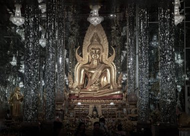 Uthai Thani, Thailand - Dec 06, 2024 - The Imitating Shinaratr Buddha Statue inside of crystal temple with complex featuring an interior adorned with shiny, mirrored tiles & columns at Wat Chantaram or Tha sung crystal temple (Wat Tha Sung). use it a clipart