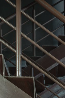 Duvara dayanan tırabzanları olan eski metal merdivenlerin dikey görüntüsü. Çelik merdivenin yan görünümü, metin için boşluk, Seçici Odaklanma.