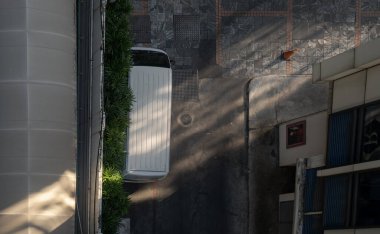 Bangkok, Thailand 23 Dec, 2024 - Top view of a white van parked next to a wall near a parking lot and morning light shining through. use it as your Wallpaper, Poster and Copy space, Selective focus. clipart