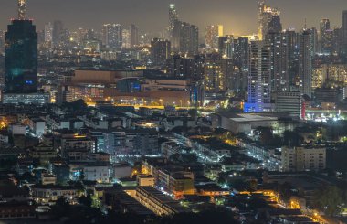 Bangkok, Tayland - 31 Aralık 2024 - Bangkok şehir merkezindeki iş bölgesinde gökdelenlerin batışından sonra Nightscape view. Günbatımından sonra şehir manzaralı modern binalar. Parlak ışıklı ışıklar. Duvar kağıdınız olarak kullanın..