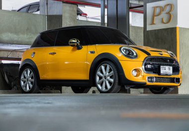 Bangkok, Tayland - 18 Ocak 2025 - park halinde park edilmiş sarı mini fıçı manzarası. Mini Cooper, İngiliz araba markasıdır. Duvar kağıdı, poster ve boşluk olarak kullanın..