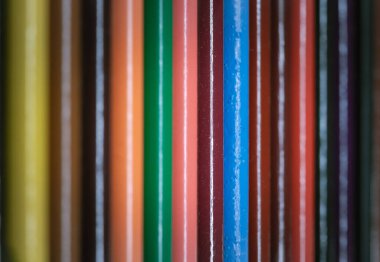 Çok renkli kalemlerin ya da ahşap pastel boyaların düzgün bir sıraya dizilmiş bir yüzey görüntüsü. Renk kalemlerinin düzenlenmesi bir birlik hissi yaratır. Doğal çevre dostu malzemelerden yapılmış kalemler, metin için boş alan, bir tasarım