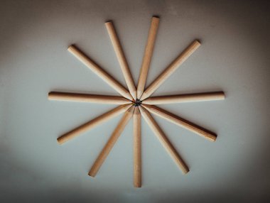 Kahverengi pastel boyaların gümüş arka planda bir daire şeklinde üst görüntüsü. Ahşap renkli kalemler bir araya gelip daire çizerler, renkli kalemlerin sanatsal gösterisi, çizim için kırtasiye malzemesi, karanlık konsept için minimalizm sanat malzemeleri, metin için boş alan, tasarım...