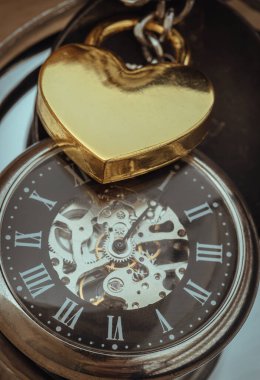 Close-up of Golden heart shaped love padlock lap over A retro pocket watch. Love can endure beyond the limitations of time, Concept of Love that transcends time, Valentine's day, use it as your Copy space, Design, Wallpaper and Poster, Selective focu clipart