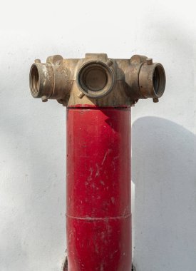 Kırmızı yangın musluğu, beyaz çimento duvar arka planında, karada yangın vanası beklentisi içinde. İtfaiye Bağlantıları, Yangın Güvenliği Konsepti, bunu metin, seçici odak için duvar kağıdı, poster ve boşluk olarak kullanın.