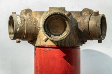 Kırmızı yangın musluğunu kapatın. Beyaz çimento duvar arka planında, karada pirinç kapakçık merdiveni var. İtfaiye Bağlantıları, Yangın Güvenliği Konsepti, Duvar Kağıdı, Poster ve Kopyalama Alanı, Seçici Odaklanma.