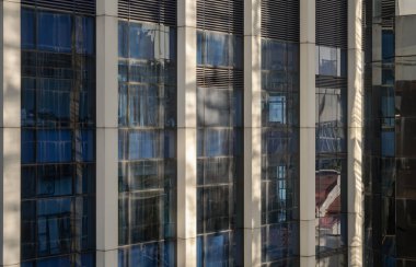 Bangkok, Tayland 23 Aralık 2024 - Mavi gökyüzü ve bulutların pencerelere yansıdığı modern bina cephesine bakış açısı. Çelik çerçeve ve cam pencere mimarisi, metin, Seçici odak için duvar kağıdı, poster ve boşluk olarak kullanın.