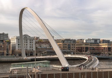 Newcastle, İngiltere - 11 Nisan 2025 - İngiltere 'nin kuzeydoğusundaki Newcastle Upon Tyne' da tarihi binalarla Tyne Nehri 'ni kaplayan Iconic Gateshead binasının manzarası. Yaya köprüsünü duvar kağıdı olarak kullanın., 