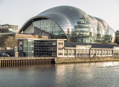 Newcastle, İngiltere - 11 Nisan 2025 - The Glasshouse International Centre for Music veya Sage Gateshead 'in mimari dış görünüşü gün batımından önce Tyne Nehri kıyısında. Yenilikçi fütürist cam bina, Newc şehrinde bir konser salonu ve kültür merkezi.