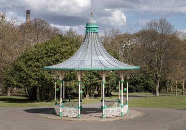 Newcastle, İngiltere - 13 Nisan 2025 - Bir Orkestra Sahnesi ve Bir Tribün Görünümü. Leazes parkına monte edilmiş Viktorya dönemi orkestrasının modern bir kopyası. Arka planda yeşil ağaçlar olan Müzik Pavyonu. Duvar kâğıdı olarak kullan Poste.